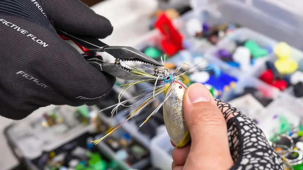 Angler using pliers to modify a trout fishing spoon, applying advanced tips and tricks to enhance lure effectiveness.